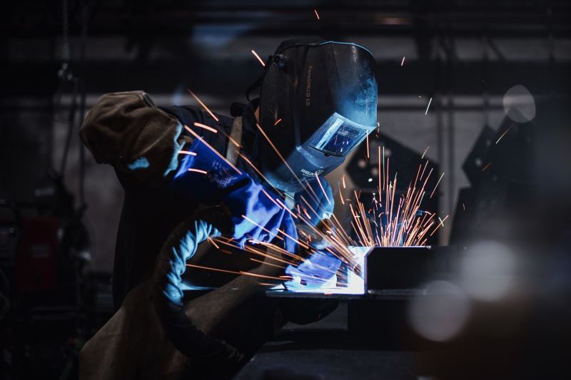 1 homme manipulant des morceaux de structure métallique pour la construction de panneau solaire chez le Groupe Le triangle