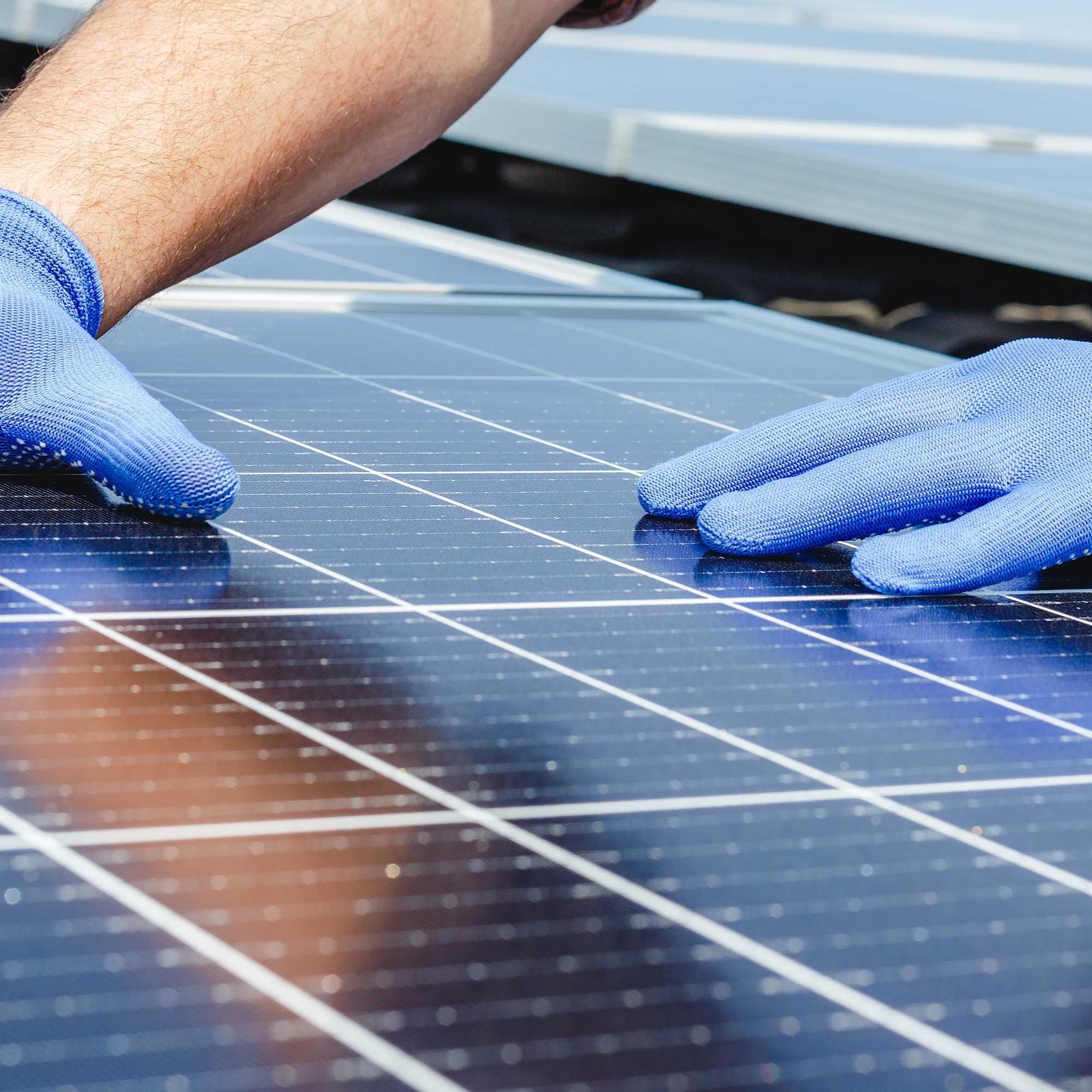 Mains posés sur des cellules de panneaux solaire construit par le Groupe Le Triangle dans le Loir et Cher