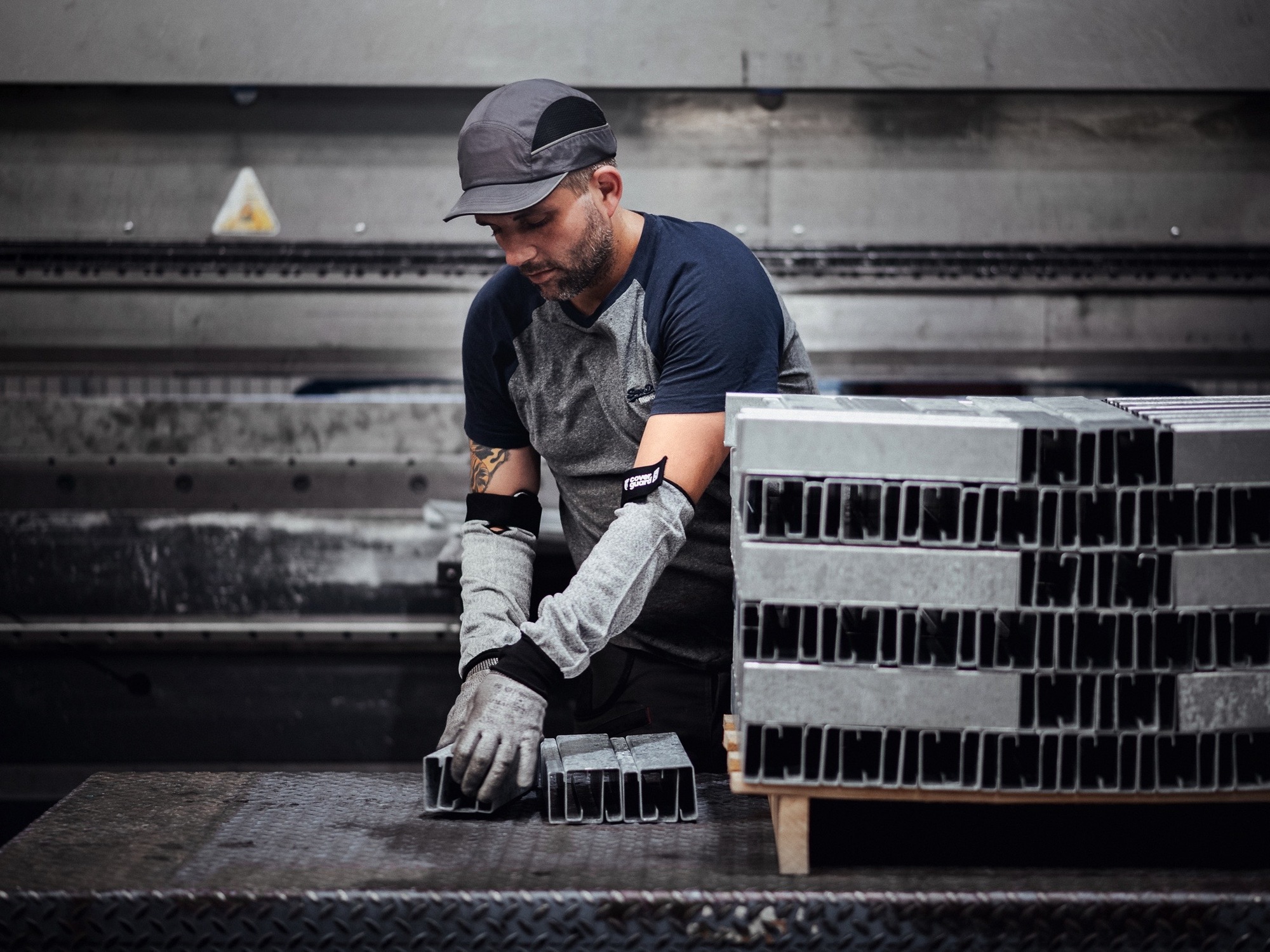 Un homme au coeur de l'atelier de production du Groupe Le Triangle en train de travailler sur une structure métallique d'un bâtiment photovoltaïque