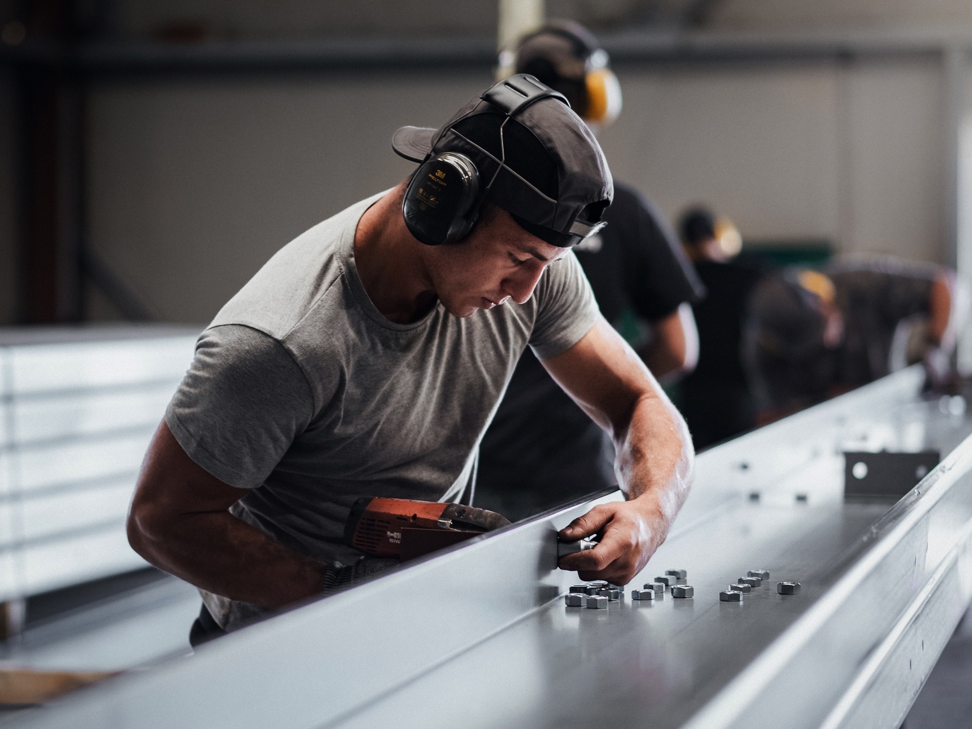 Un homme au coeur de l'atelier de production du Groupe Le Triangle en train de travailler sur bâtiment photovoltaïque