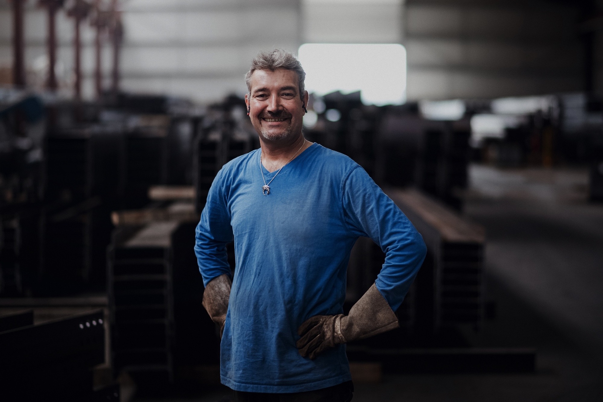 Un homme au coeur de l'atelier de production du Groupe Le Triangle en train de travailler sur une structure pour ombrière solaire
