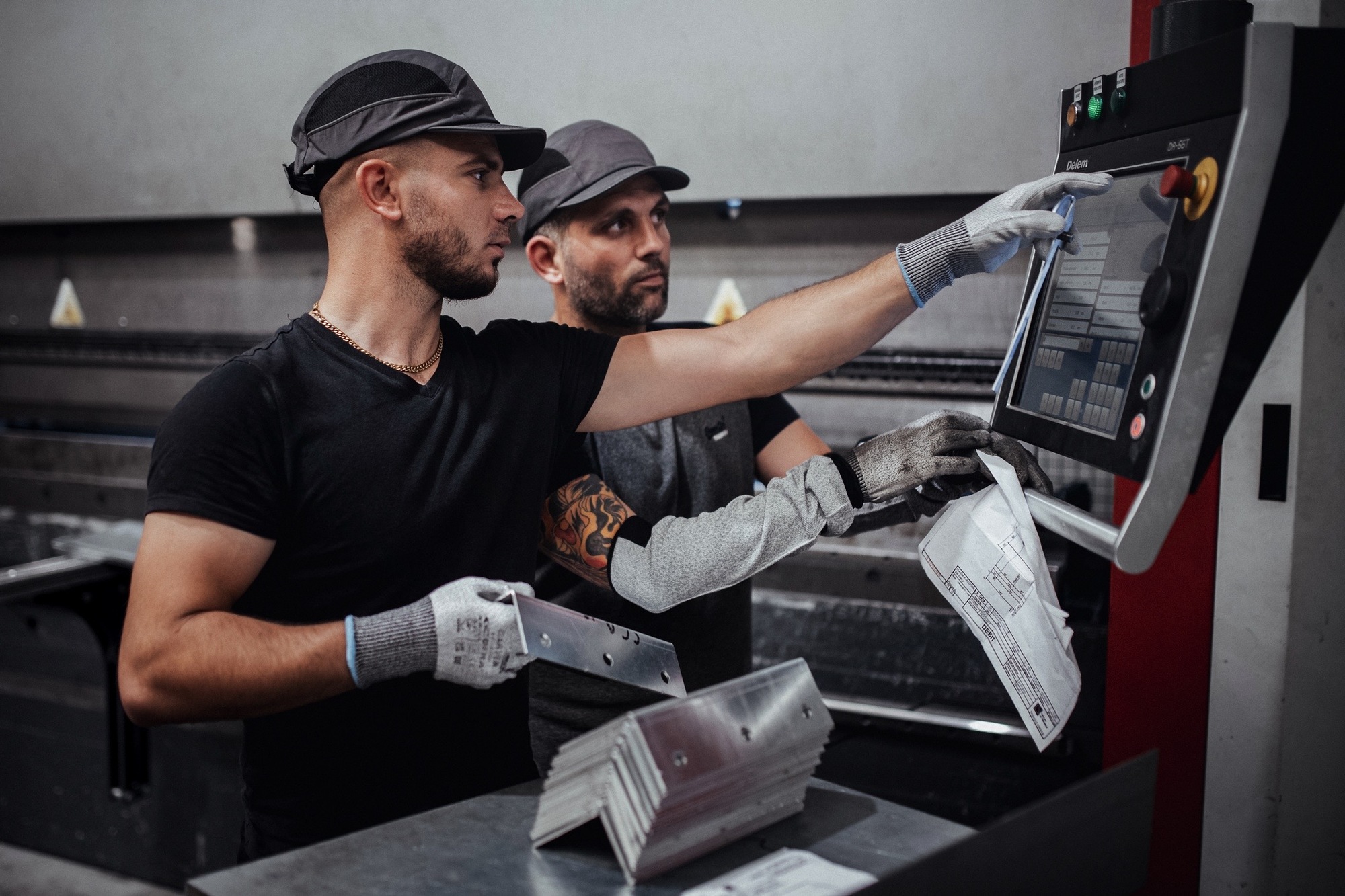 2 hommes pliant des morceaux de structure métallique pour la construction de panneau solaire chez le Groupe Le triangle
