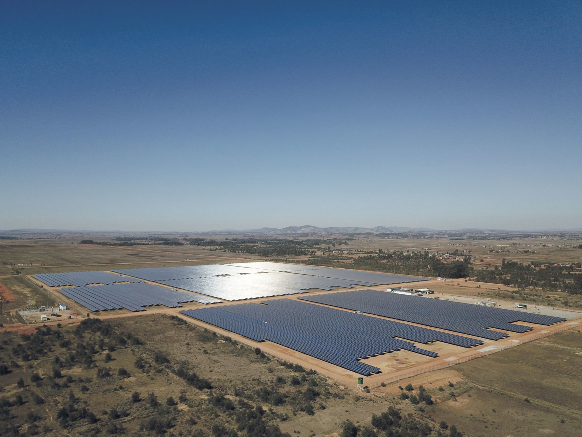 Installation photovoltaïque extensive de Le Triangle avec des structures métalliques robustes, déployée sur un terrain ouvert sous un ciel dégagé.