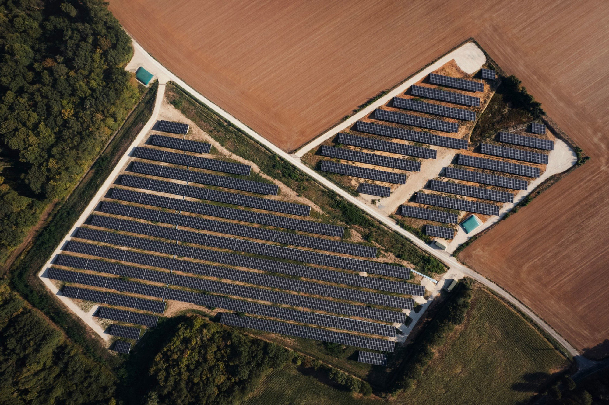 Réalisations solaires de Le Triangle, montrant des panneaux solaires alignés sur une structure métallique, illustrant l'efficacité énergétique dans un champ.