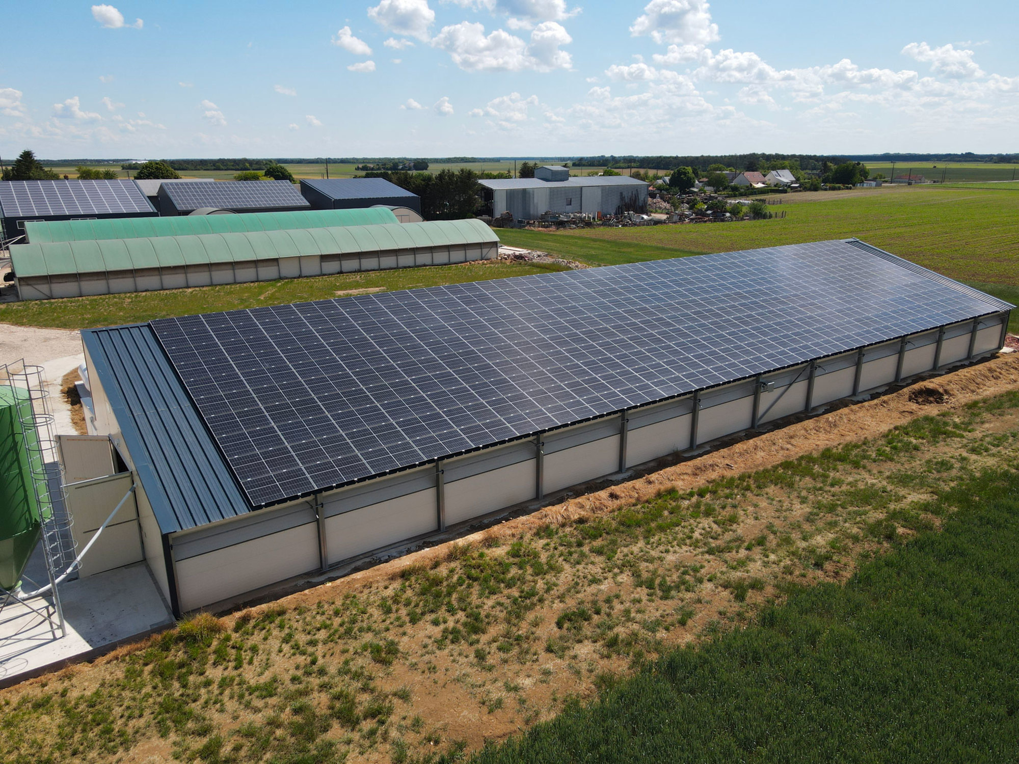 Bâtiment agricole équipé d'un grand toit photovoltaïque par Le Triangle, démontrant une solution d'énergie renouvelable pour l'agriculture.