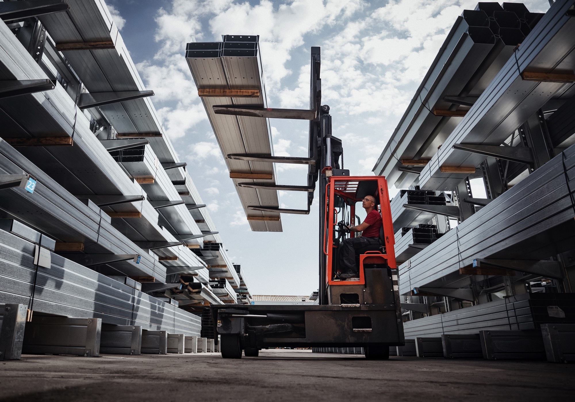 1 homme dans un chariot élévateur dans une zone de stockage de structure métallique, panne métallique pour la construction de panneau solaire et structure photovoltaïque