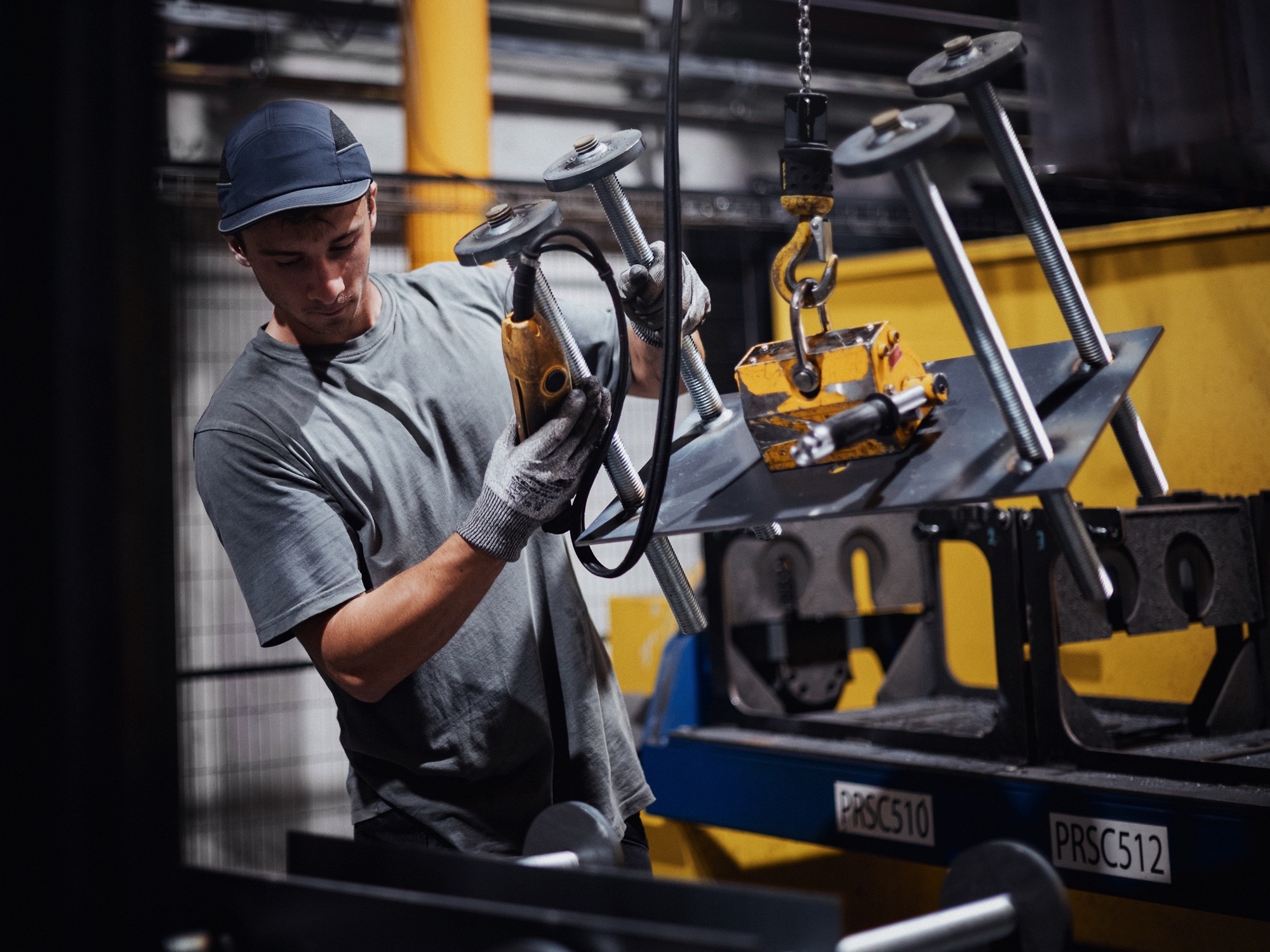 1 homme manipulant des structures métalliques pour la construction de panneau solaire chez le Groupe Le triangle, leader industriel du photovoltaïque